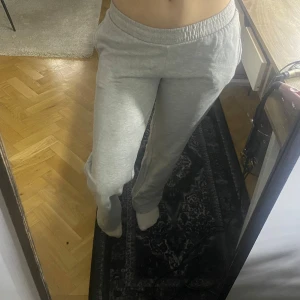 Grå mjukisbyxor  - Säljer ett par grå mjukisbyxor med resår i midjan. Byxorna har en normal passform och raka ben, perfekta för en avslappnad stil. Tillverkade i mjukt bomullsmaterial för extra komfort. jag är 160 och dom är inte för korta, dom går över mina skor om jag skulle haft på mig!! (säljer för jag känner att xs är lite litet)💞