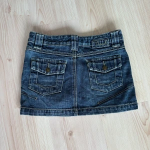 Kort jeanskjol från Diesel - Jättefin kort lågmidjad jeanskjol från Diesel som tyvärr är för liten för mig😫Jag är en typisk S/36/38 men denna är i storlek 26 så den hade nog passat på någon i stl XS/XXS❤️‍🔥Midjan är ca 38 cm mätt rakt över och längden är ca 29 cm fram och 31 cm bak