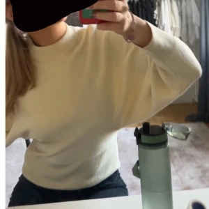 Vit stickad tröja med resår i midjan - Super fin tröja me resår i midjan, ballong ärmar. Resåren är lite uttöjd i midjan då ja köpt den secondhand. Men de e inget som syns när den sitter på 