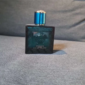 Versace Eros Eau de Toilette 50ml - Versace Eros Eau de Toilette för herr, 50 ml. Flaskan är fyrkantig i turkost glas med Medusa-huvudet i relief och ett blått metallock. Doften är fräsch och maskulin, perfekt för dig som gillar exklusiva parfymer.