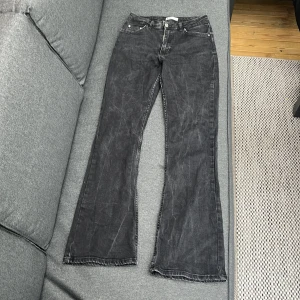 Grå bootcut jeans från Gina Tricot - Säljer ett par grå bootcut jeans från Gina Tricot med klassisk femficksdesign och normal passform. Jeansen är tillverkade i denim med lätt tvättad look. Perfekta för dig som gillar en tidlös stil.