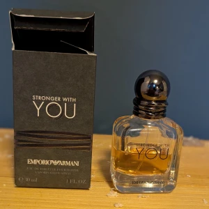 Emporio Armani Stronger With You EdT 30ml - Emporio Armani Stronger With You är en herrparfym i en stilren, transparent glasflaska med rundad svart kork. Doften är varm och kryddig, perfekt för dig som gillar eleganta och moderna parfymer. Flaskan rymmer 30 ml Eau de Toilette. Det är lite mer än hälften kvar.