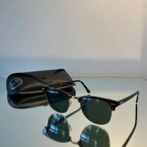 Ray-Ban Clubmaster solglasögon - Klassiska Ray-Ban Clubmaster solglasögon med brun  båge och svart glas. Metallbågar i guldton och detaljer vid gångjärnen. Kommer med original Ray-Ban-fodral!