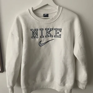 Vintage sweatshirt Nike Vit - Säljer en vintage vit sweatshirt från Nike med broderad logga på framsidan. Notera sista bilden, en liten fläck som inte går bort i vanlig tvätt. Ej testat med vanish eller liknande produkter. Går säkert att bleka annars passar S/M.