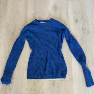 Blå stickad tröja från Carin Wester - Säljer en snygg blå stickad tröja från Carin Wester. Tröjan har en klassisk design med långa ärmar och rund hals. Passar perfekt med ett par jeans.