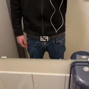 Svart bälte från Fendi med silverdetaljer - Svart fendi bälte som säljs pga ingen användning.Perfekt för att ge en lyxig touch till din outfit. Kommer i originalförpackning. Man får med en liten påse för bältet och boxen 