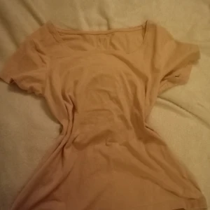 Beige kortärmad topp - Säljer en enkel och stilren beige topp med korta ärmar. Perfekt för en avslappnad look. Storlek L men passar som M