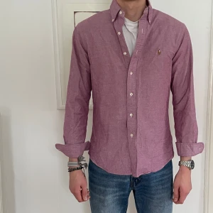 Rosa Ralph Lauren skjorta  - Snygg rosa Ralph Lauren skjorta med knappar och klassisk krage. Perfekt för en stilren look. 