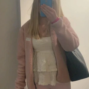 Beige linne med volanger - Säljer ett sött beige linne med volanger. Toppen har smala axelband. Sååå himla fin och har bara använt få gånger. Materialet är lätt och bekvämt.