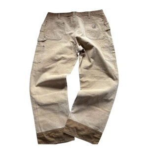 90s Sällysynta double color Carhartt double knee workpants - Väldigt sällsynt färgkombination på dessa Carhartt Double Knees med snygg distressing                                     Måtten: midjebredd: 49cm, total längd: 107cm, ben öppning: 25cm. Baggy fit                                                           Fin lagning i grenen av en skräddare, gott skick överlag för dess ålder                
