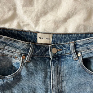 Blå jeans från Abrand Jeans - Snygga blå jeans från Abrand Jeans med klassisk femficksdesign och knappgylf. De har en rak passform och är perfekta för en avslappnad stil. Jeansen har en diskret logga på bakfickan. I modellen A’94 High straight. Jag är 168 och brukar har stl s!