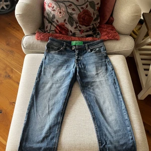 Blå jeans från United Colors of Benetton - Snygga blå jeans från United Colors of Benetton med klassisk femficksdesign och knappgylf. Perfekta för en avslappnad stil.