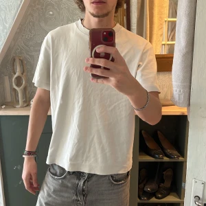 Vit t-shirt från Zara - Säljer en stilren vit t-shirt från Zara. Den har en klassisk design med korta ärmar och rund hals. Perfekt för en enkel och avslappnad look.