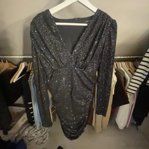 Svart glittrig klänning  - Snygg svart glittrig klänning. Helt ny med prislappen kvar. Storlek 36