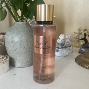 Bare Vanilla Fragrance Mist från Victoria's Secret - Säljer en flaska Bare Vanilla Fragrance Mist från Victoria's Secret. Den har en söt och krämig doft av vispad vanilj och mjuk kashmir. Flaskan är genomskinlig med en gyllene kork och rymmer 250 ml.