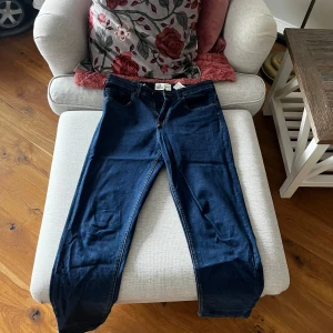 Mörkblå jeans från Springfield - Snygga mörkblå jeans från Springfield i modellen Regular. De har en klassisk femficksdesign och en bekväm passform. Perfekta för en stilren look.