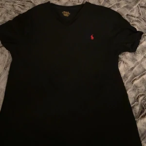 Svart t-shirt från Ralph Lauren - Äkta svart t-shirt från Ralph Lauren med röd broderad logga på bröstet som är V ringad. Köpt för 1000