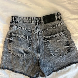 Grå jeansshorts med slitningar - Snygga grå jeansshorts från new yorker med coola slitningar och fransiga kanter. De är högmidjade och är perfekt i längden! 