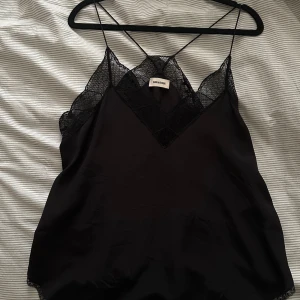 Svart linne från Zadig - Snyggt svart linne från Zadig med spetsdetaljer och tunna axelband. Perfekt för en stilren look. Passar s-m ungefär.