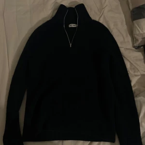 Mörkblå stickad tröja från Soft Goat - Säljer en mörkblå stickad tröja från Soft Goat med dragkedja. Tröjan har en hög krage och långa ärmar, perfekt för kyligare dagar. Den är gjord i ett mjukt och bekvämt material. Nypris 2695kr