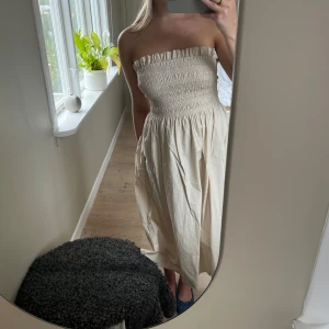 Beige bandou-klänning - Säljer en supersöt beige klänning från H&M. Denna klänningen är perfekt för sommaren. Den passar mig som vanligtvis har storlek M. 