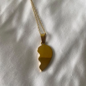 Guldigt halsband med halvt hjärta - Säljer ett halsband med ett guldigt halvt hjärta! Perfekt som vänskapshalsband eller att matcha med någon annan.  