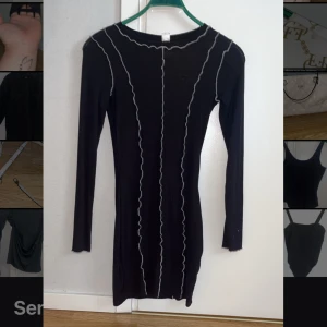 Svart långärmad klänning med vågiga sömmar - Passar 32,34, 36 och 38. Säljer en svart långärmad klänning med dekorativa vita vågiga sömmar längs hela klänningen. Tight passform och rund halsringning. Perfekt för dig som gillar minimalistisk men unik stil.