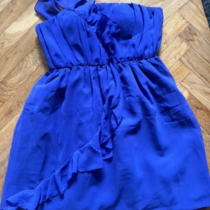 Blå one shoulder klänning med volang - Säljer en snygg blå one shoulder klänning med volangdetalj framtill. Så fin nu till sommaren och i toppen skick❤️❤️ i storlek M men passar definitivt S också! Köpte för 400 men säljer för 250 men öppen för prisförslag !