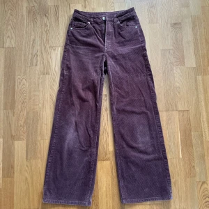 Bruna manchesterbyxor från Divided - Säljer ett par bruna manchesterbyxor från Divided med raka, vida ben och klassisk femficksdesign. Byxorna har hög midja och stängs med dragkedja och knapp. Perfekta för dig som gillar retrostil och mjuka material.