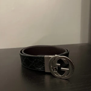 Gucci Bälte - Säljer ett Reversible bälte från Gucci med klassiskt GG-mönster i lädret och ett stort, rundat spänne i silverfärg. Bältet levereras med box och dustbag. Perfekt accessoar för att lyfta din outfit. Kvitto finns tyvärr inte men bältet är köpt från Kaspersheat!