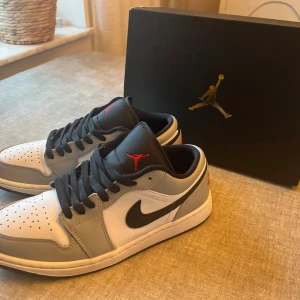 Air Jordan 1 Low Light Smoke Grey  - Storlek 42. Använda men i skick som nya, finns väldigt få och små tecken på användning. Köpta från merchsweden.se för 3499 kr  