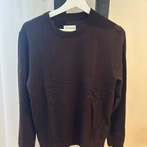 Mörkbrun tröja från These Glory Days - Säljer en stilren mörkbrun tröja från These Glory Days. Tröjan har rund halsringning och långa ärmar, perfekt för lager-på-lager eller som den är. Enkel och klassisk design som passar till mycket.