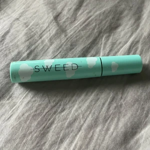 Sweed mascara  - Mascara från Sweed i en ljusblå tub med vita molntryck. Borsten är smal och har täta piggar för att separera fransarna. 