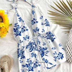 Vit och blå blommig halterneckklänning - Superfin somrig top med vit bas och blått blommönster. Halterneck med knyt i nacken och markerad midja med knytband. Aldrig använd💙