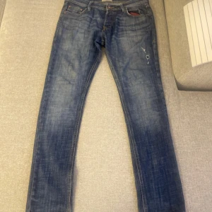 Blå slim fit jeans från Jack & Jones - Säljer ett par blå slim fit jeans från Jack & Jones, modell Glenn. Jeansen har klassisk femficksdesign, dragkedjegylf och snygga slitningar framtill. Perfekta för dig som gillar en smalare passform och tidlös denimstil. PRISET KAN DISKUTERAS!