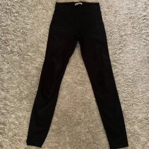 Svarta leggings från Denim Co. - Svarta leggings från Denim Co. med tight passform och klassisk design. Byxorna har resår i midjan och är tillverkade i ett stretchigt material som sitter bekvämt. Perfekta att matcha med en oversized tröja eller hoodie.