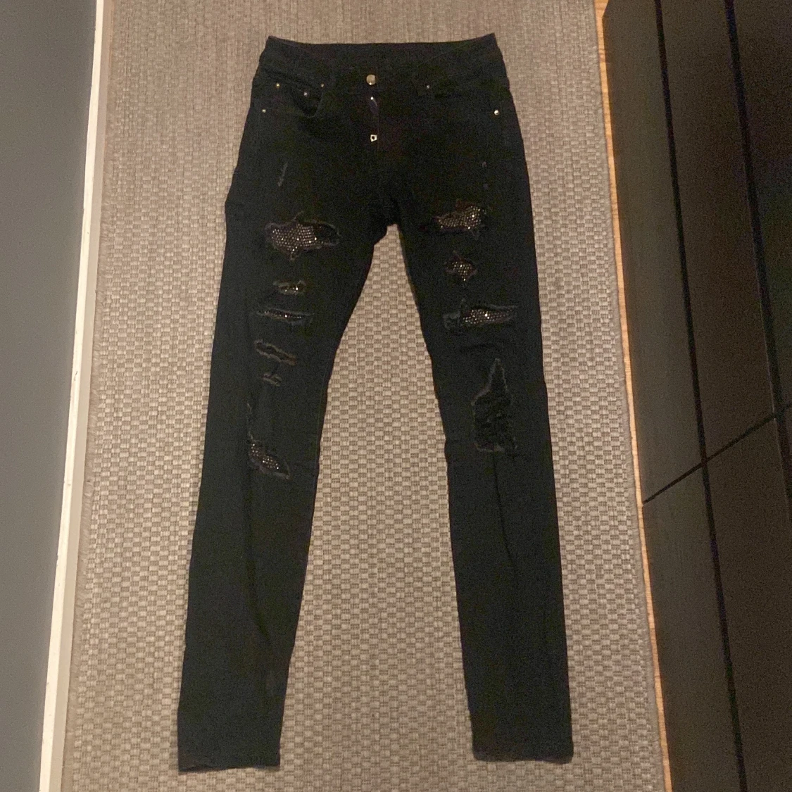 Svarta skinny jeans med slitningar och paljettdetaljer