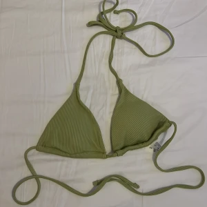 Olivgrön ribbad trekantsbikini - Snygg olivgrön trekantsbikini med ribbad struktur och knyt i både nacke och rygg. Perfekt för stranddagar och sommarens bad. Enkel och stilren design som passar till mycket.