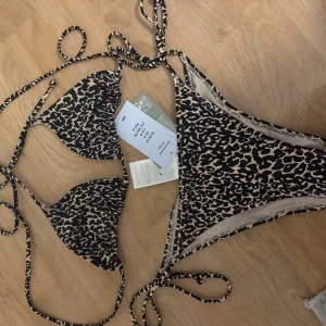 Leopardmönstrad bikini  - Säljer en snygg leopardmönstrad bikini från H&M i storlek S. Bikinin har trekantsöverdel med knyt i nacke och rygg samt tanga-underdel med knyt i sidorna. Perfekt för sommaren!