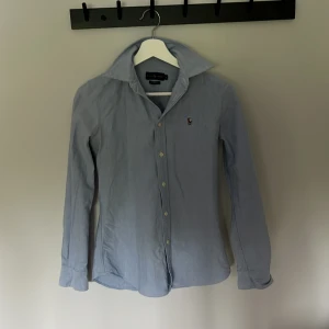 Ljusblå skjorta från Ralph Lauren - Polo Ralph lauren skjorta i riktigt fint skick, inga defekter. Säljer den för att den blev för liten. Kontakta mig vid frågor👍🏼😀