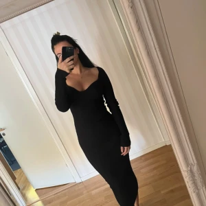 Svart ribbad långklänning H&M XS - Säljer en svart ribbad långklänning från H&M i storlek XS. Pasar en storlek S/Mdå materialet är stretchigt. Klänningen har lång ärm, v-ringad och figurnära passform som framhäver siluetten. Materialet är mjukt och stretchigt, perfekt för dig som gillar stilrena och enkla looks.