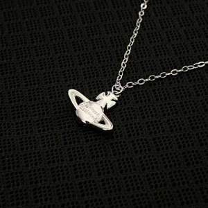 L’Orbite de Saturne - Elegant necklace with a Saturn-inspired pendant, measuring 1.5 cm tall and 2 cm wide, on a 45 cm chain. Minimalist yet striking.