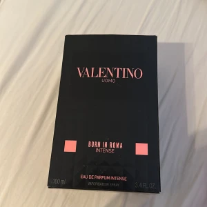 Valentino Uomo Born In Roma Intense - Exklusiv herrparfym från Valentino, Born In Roma Intense. Kommer i en snygg svart kartong med rosa detaljer och rymmer 100 ml Eau de Parfum Intense. Perfekt för dig som gillar lyxiga och djupa dofter med modern känsla.
