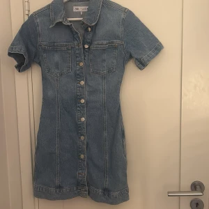 Jeansklänning - Trendig jeansklänning från Zara med korta ärmar och knappar framtill. Storlek M men sitter mer som S