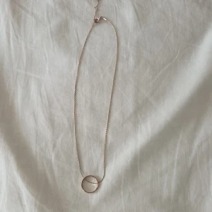 Enkelt halsband med cirkel i roseguld - Snyggt och minimalistiskt halsband i roseguldton med en tunn kedja och en rund cirkel som hänge. Perfekt för dig som gillar stilrena smycken med en modern touch. Passar till alla outfits och är lätt att matcha med andra smycken. Något sliten (se bilder) men syns mest på nära håll 