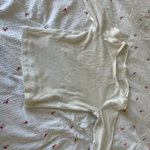 Vit ribbad långärmad tröja H&M - Säljer en vit långärmad tröja från H&M i storlek 158/164. Tröjan är ribbad och har en enkel, clean design med rund hals. Perfekt att styla med jeans eller kjol för en chill look. Materialet är mjukt och stretchigt, vilket gör den skön att ha på sig hela dagen.