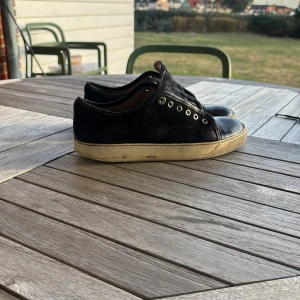 Svarta sneakers från Lanvin i skinn och mocka - Säljer nu dessa lanvin cap toes för endast 500 hurdra kr! Skosnören måste byttas då original snörena gick sönder och jag fick bytta. Längst fram på höger sko har en bit av sulan gått av. Man kan också se att vid sulan har mycket gått sönder detta gör att man kan få in stenar och vatten i skon. Därav de låga priset!                                                  Är vilken storlek skorna är men har funkat för mig som 40, 41,42. 