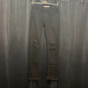 Svarta Levi's 510 Skinny jeans - Säljer ett par svarta Levi's 510 Skinny jeans med klassisk femficksdesign och smal passform. Jeansen har en stilren look med diskreta sömmar och Levi's ikoniska patch bak. Perfekta för dig som gillar en tajt siluett och svart denim. Dom är dock lite små i storleken.