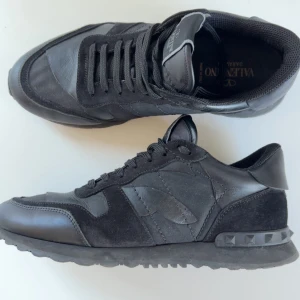 Valentino Rockrunner - Svarta Valentino Garavani rockrunner är i ny skick. Skorna är i storlek 41 men passar även 41,5. Skorna är gjorda i en mix av skinn och mocka, har ett snyggt mönster på sig o nitar på sulan. Perfekta för dig som vill ha en lyxig men bekvämlig sko.