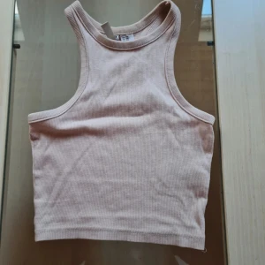 Beige ribbad linnetopp från H&M Divided - Säljer en ljusbeige croppad linnetopp från H&M Divided. Toppen är ribbad och ärmlös med klassisk rund halsringning och tight passform. Perfekt att styla med jeans eller kjol för en clean look. Går att köpa 3-pack (kolla mina annonser)